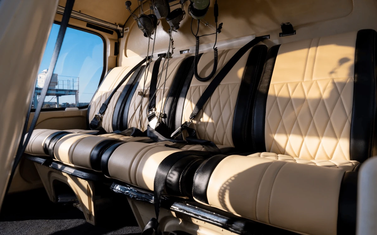 Leere cremefarbene Ledersitze und Headsets in der Kabine eines Helikopters