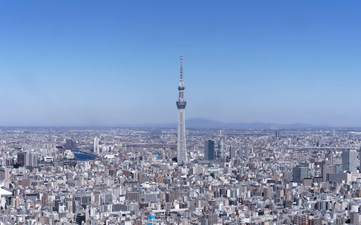 Der Skytree tower über niedrigen Stadtblöcken unter klarem Himmel