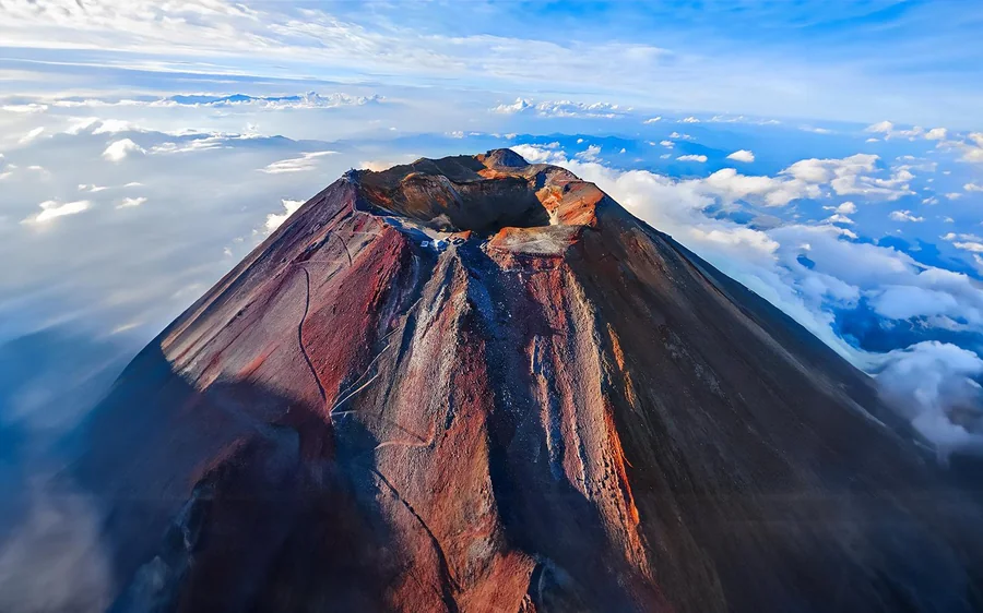 Der rote Kraterrand des Mt. Fuji von oben über den Wolken